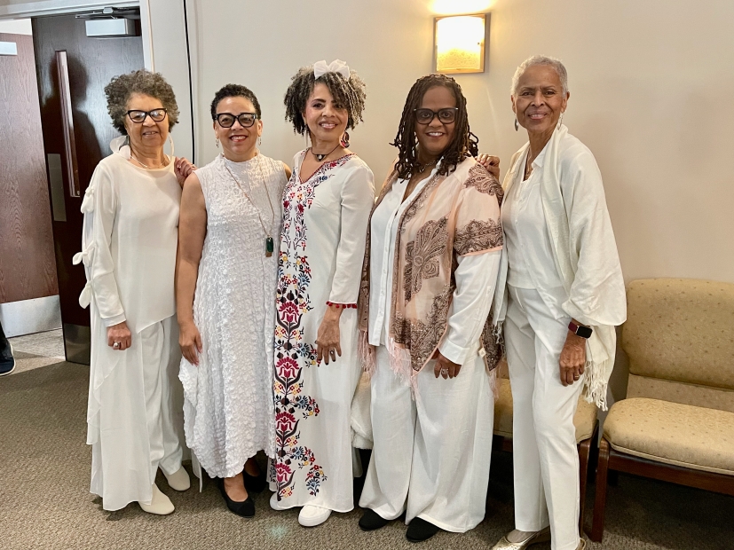 Group of five Black women dressed in all white, flowy clothing