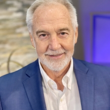 Reverend Neusom Holmes wearing blue suit, white shirt, smiling in Unity of the Triangle sanctuaryr