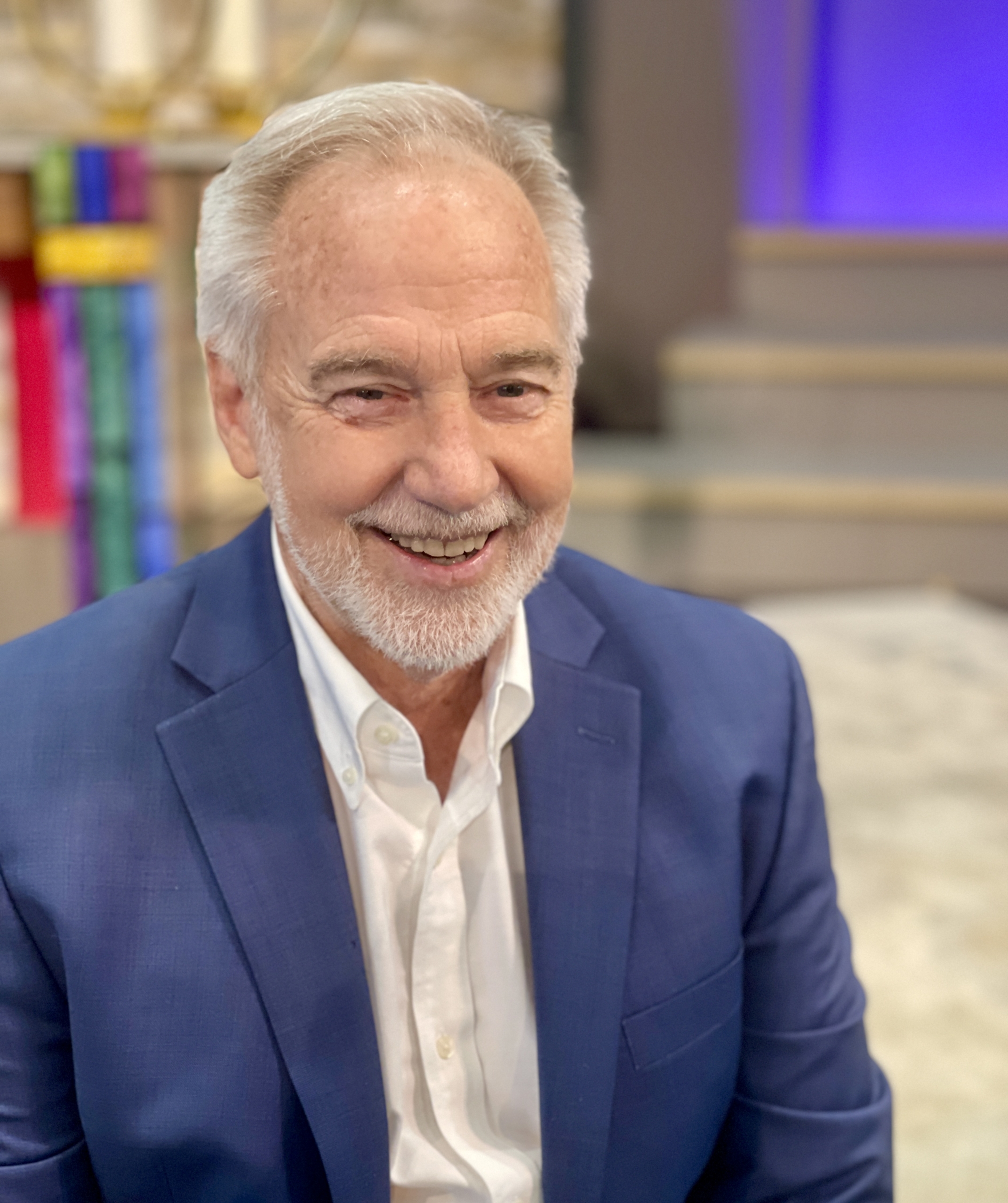 IMG_1287crop Reverend Neusom Holmes wearing blue suit, white shirt, smiling in Unity of the Triangle sanctuary