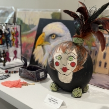 whimsical mask of a woman's face with a feather top of head