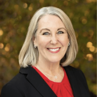 Deb McCutcheon wearing black blazer and red blouse.