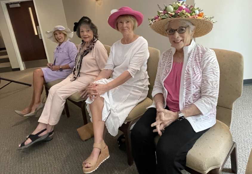 four women dressed in easter pastel clothing wearing easter bonnets