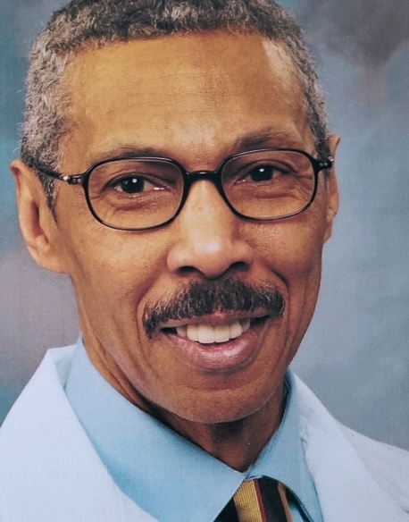 Dr. Terry Gordon, African American man with salt and pepper hair, black rimmed glasses, wearing blue shirt, striped tie and white doctor coat