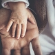 a baby's hand resting on the palm of an adult male hand