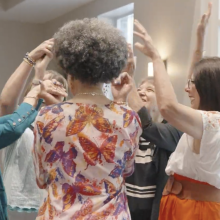 welcometeamGO TEAM.081025 5 women gathered in a circle with arms in the air in spontaneous celebration