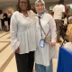 Rev Tami Johns wearing white flowy blouse and black pants. Woman dressed in muslim headdress, and white flowy blouse.